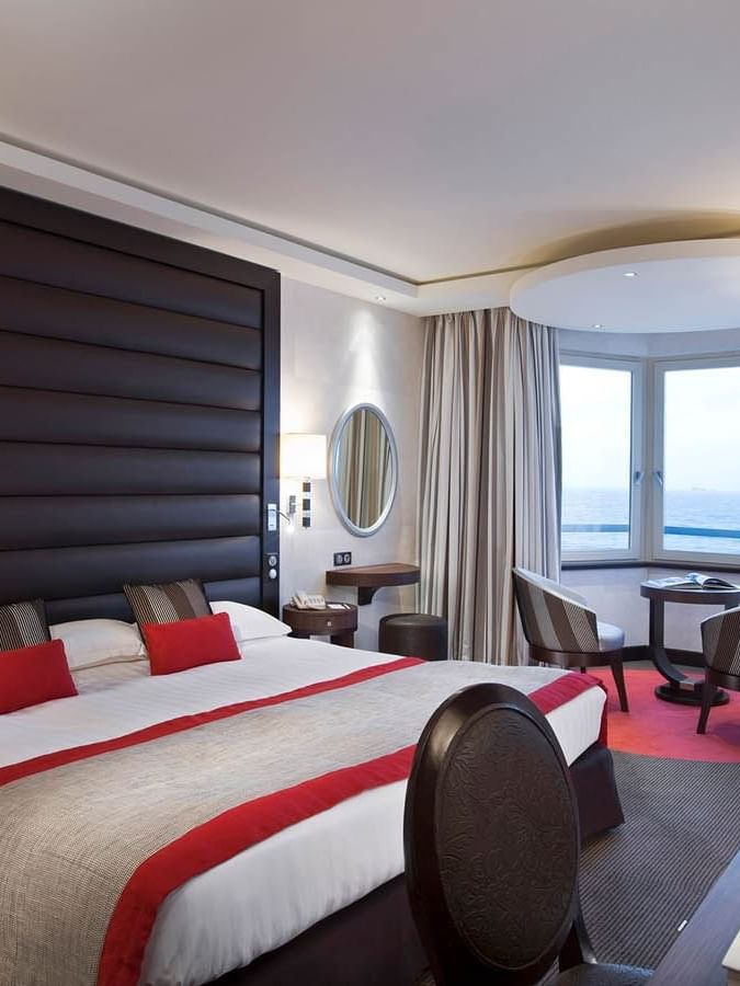 Double bed facing work desk & seating area with city view in Croisiere Grand Large Room at Le Grand Hôtel des Thermes