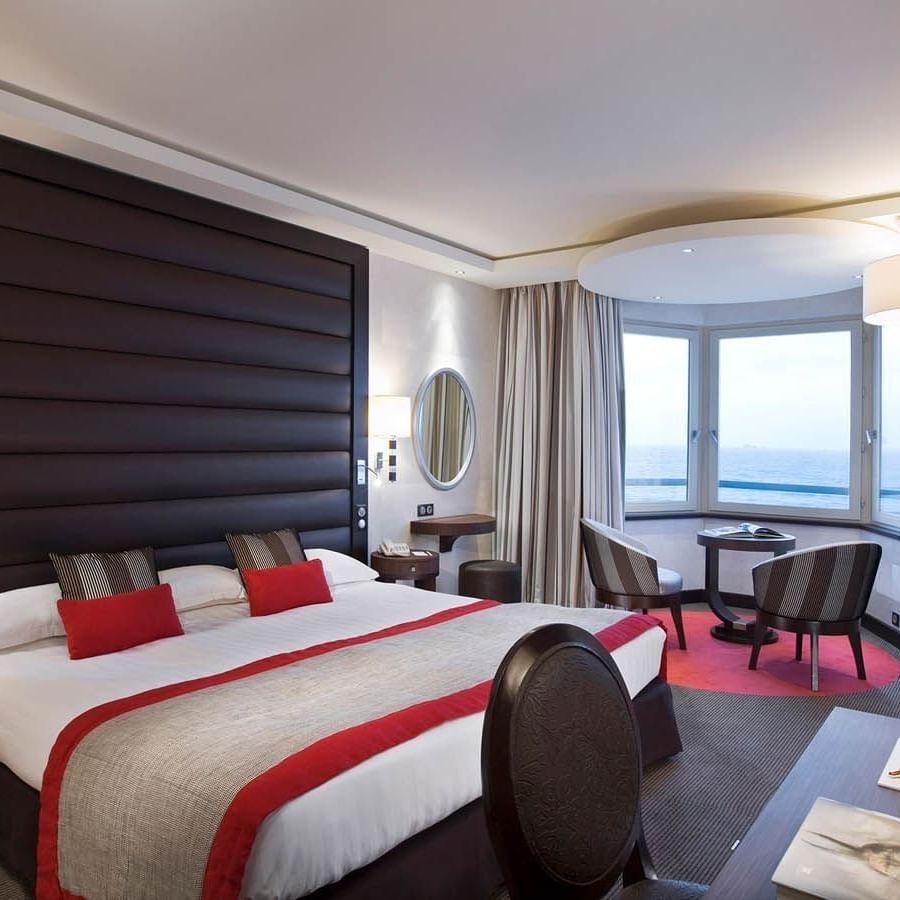 Double bed facing work desk & seating area with city view in Croisiere Grand Large Room at Le Grand Hôtel des Thermes