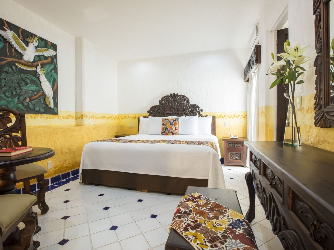 room with bed, small dressing table and yellow wallpaper