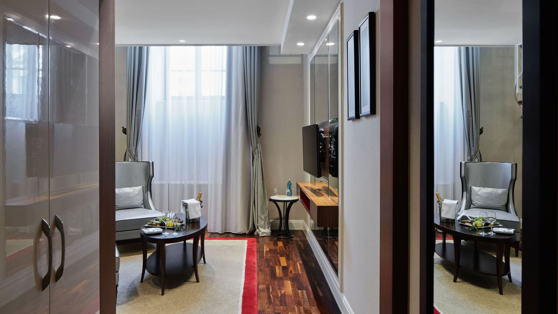 TV lounge area of Gendarmenmarkt Duplex Suite with chairs & carpet at Titanic Gendarmenmarkt Berlin