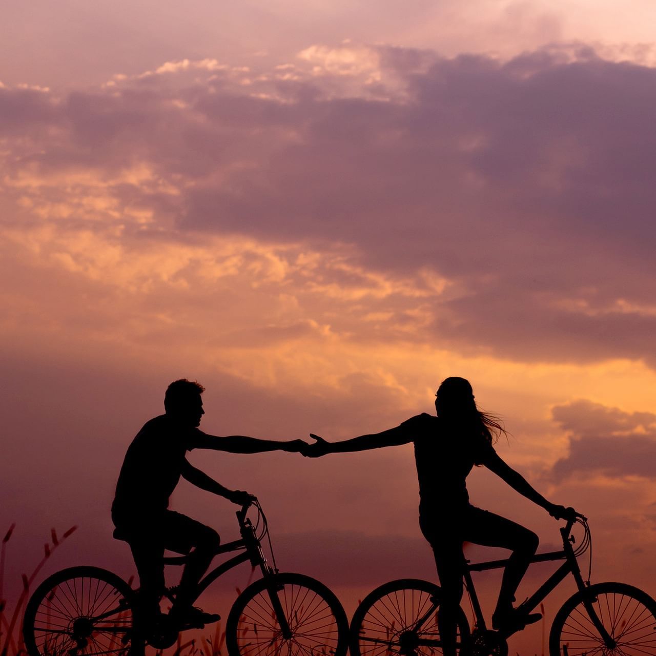 Couple holding hands while biking at U Hotels & Resorts