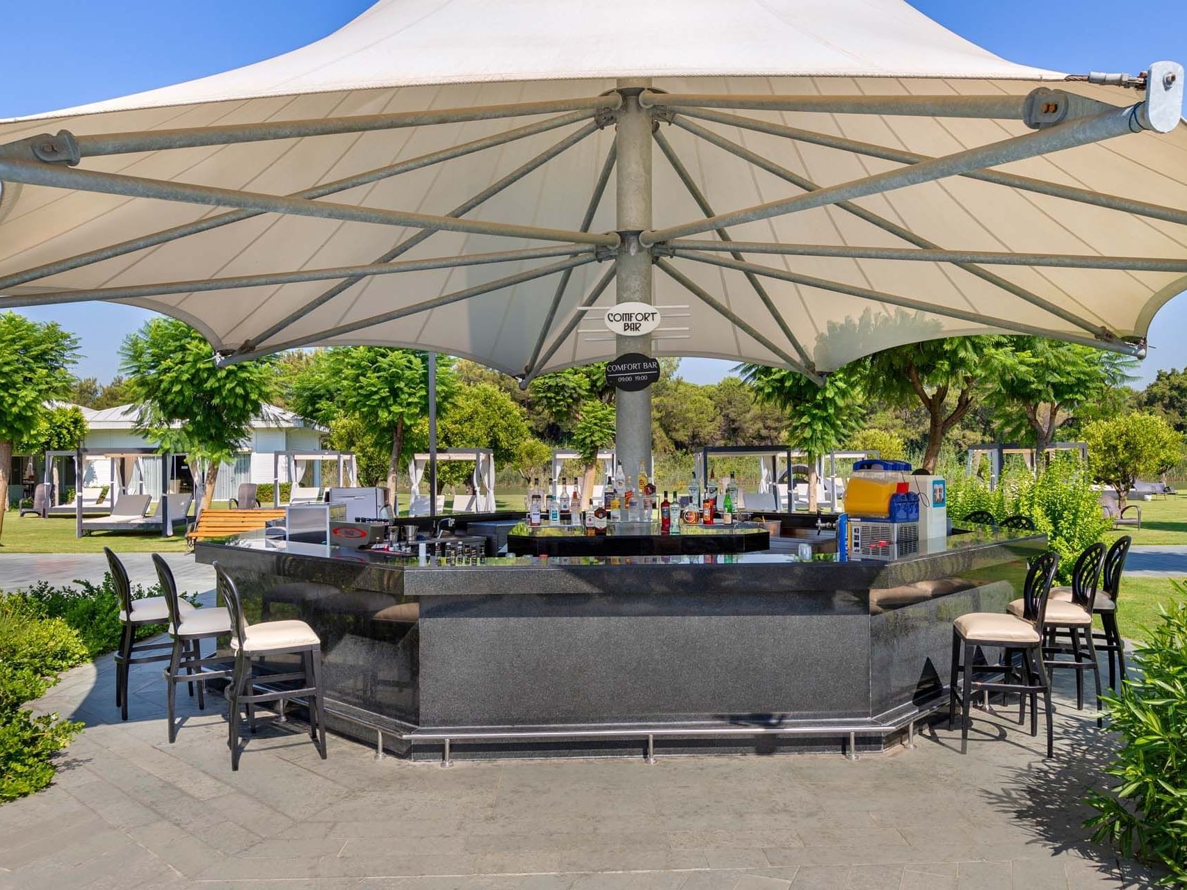 Outdoor bar counter area arranged with chairs at Titanic Deluxe Golf Belek