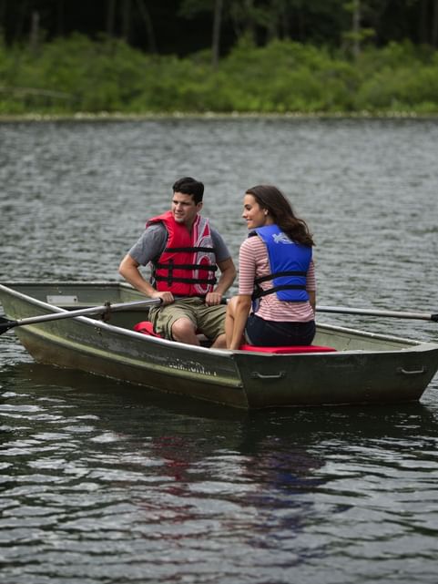 Couple observing the surrounding while enjoying a relaxing rowboat experience near Cove Pocono Resorts