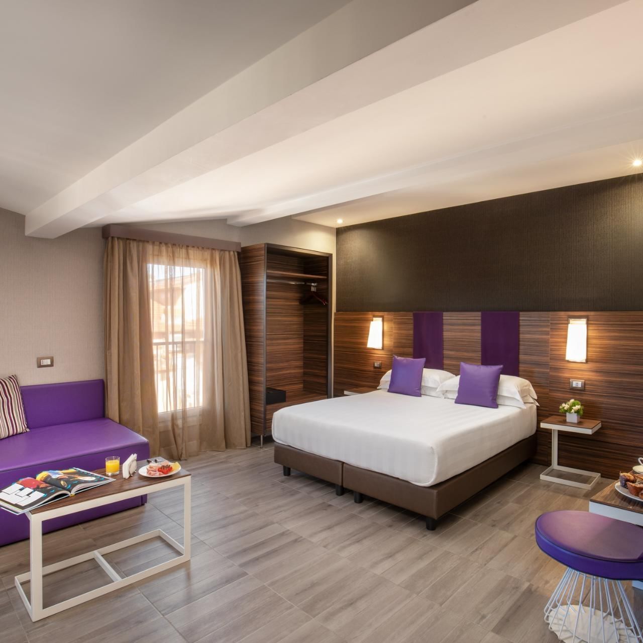 The Republic View Suite featuring a double bed, a cozy sofa, and a dining table with breakfast at The Republic Hotel