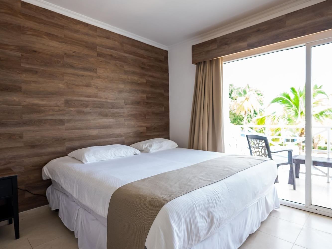 Garden View room with one king size bed and sliding doors to a balcony with a view at Playa Blanca Beach Resort