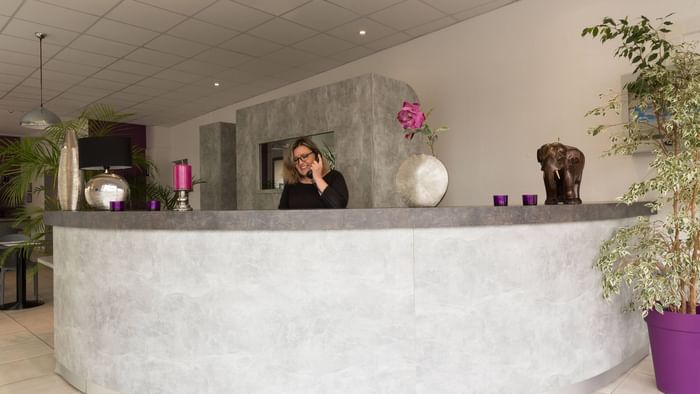 A receptionist at the reception of Hotel Nevers Centre Gare