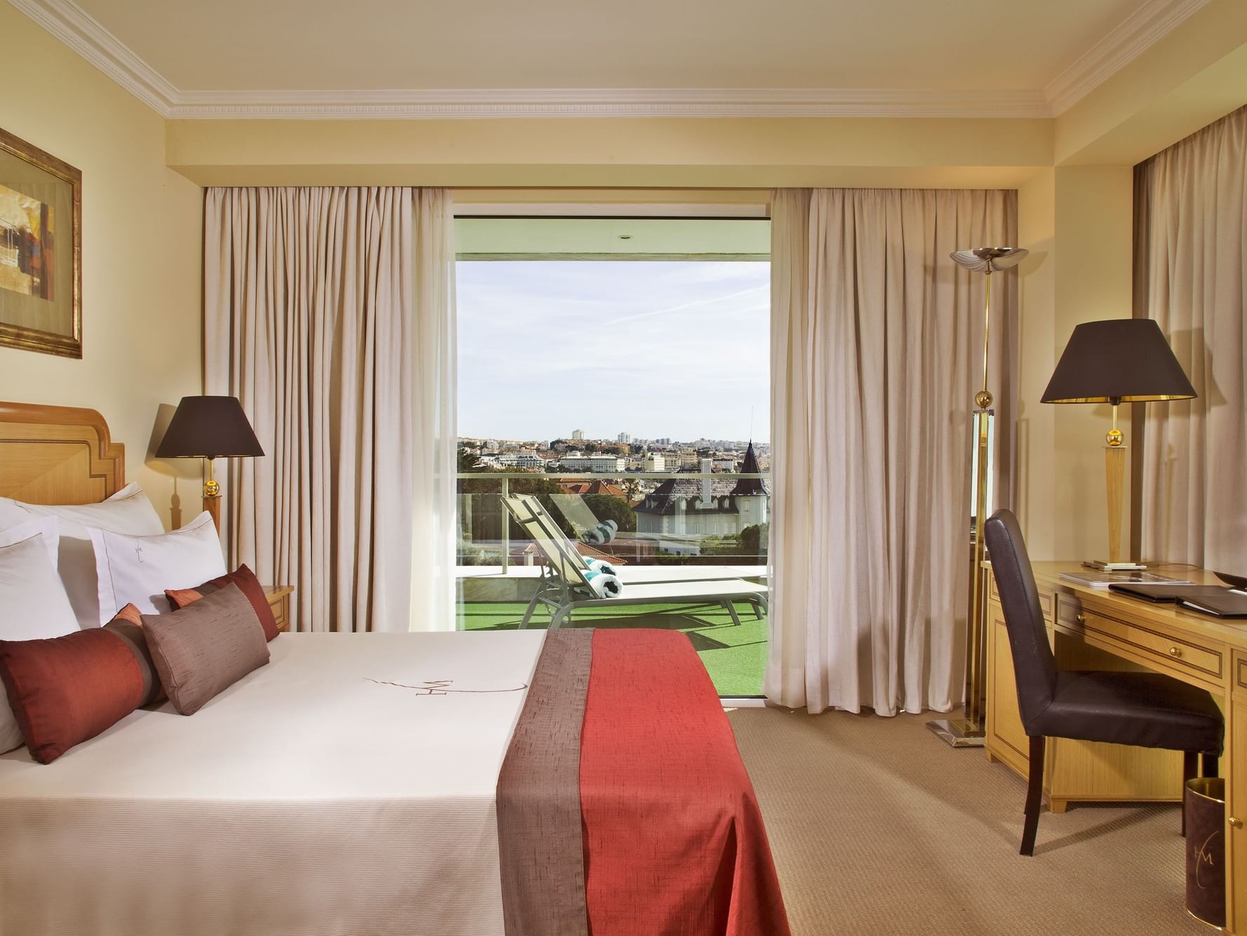Work desk facing the bed with a city view in a Suite at Hotel Cascais Miragem Health & Spa