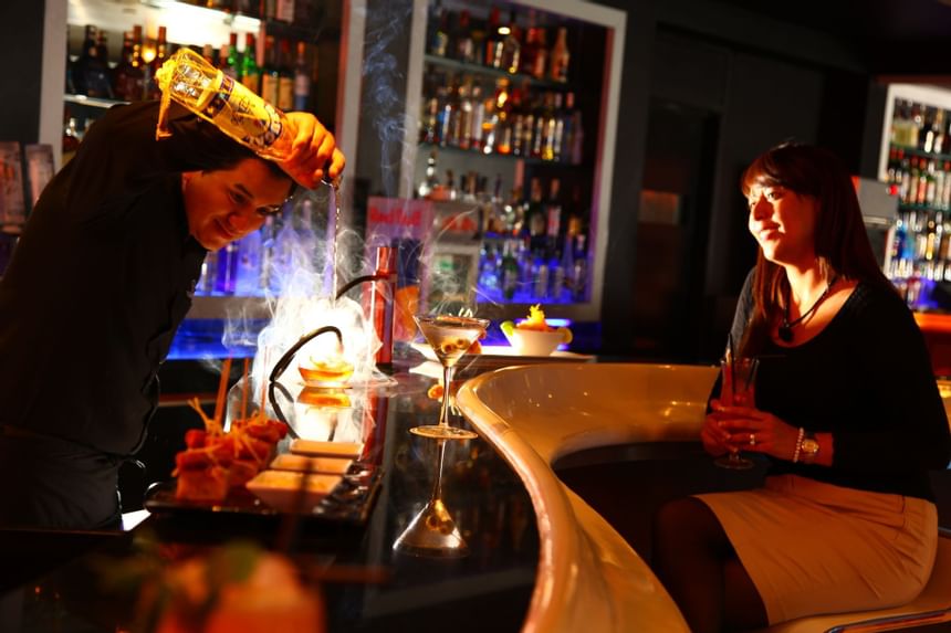 Camarero haciendo bebidas en Oceanus Lounge Bar en Delfines Hotel