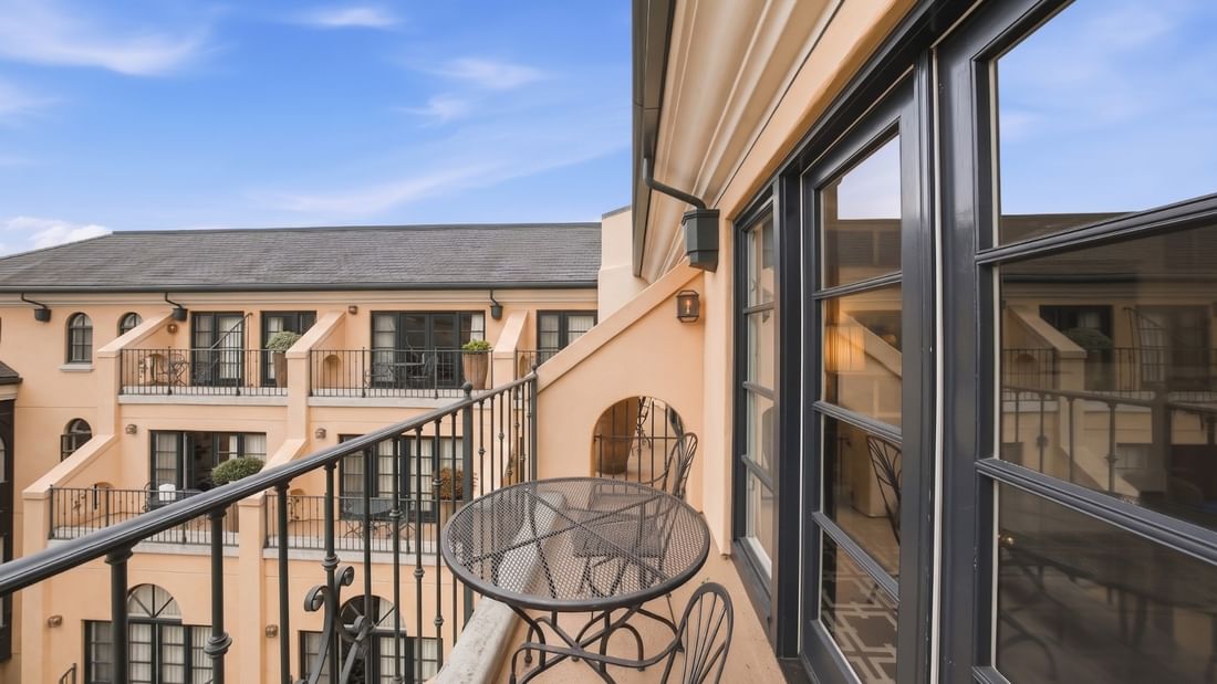 Deluxe King balcony with metal bistro table and chairs overlooking courtyard at el PRADO Hotel in Palo Alto.