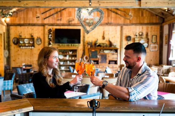 Ein Paar bei der Bar trinken einen Cocktail im Vitalhotel Gosau