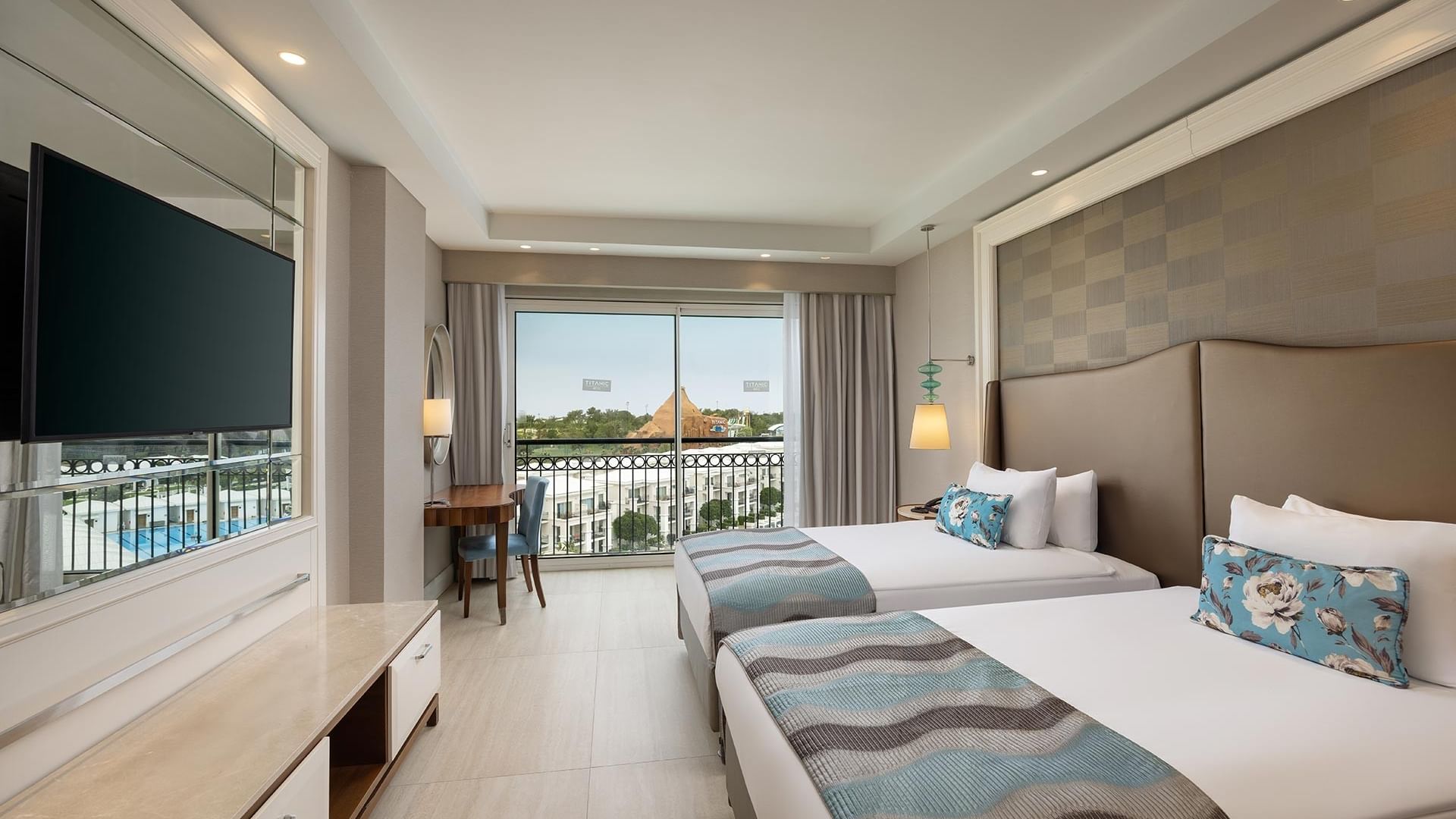 Elegant Corner Suite with two beds and balcony view at Titanic Deluxe Golf Belek in Antalya.