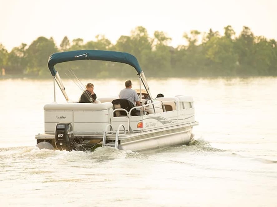 Two people riding on a boat on the lake near Chase on The Lake