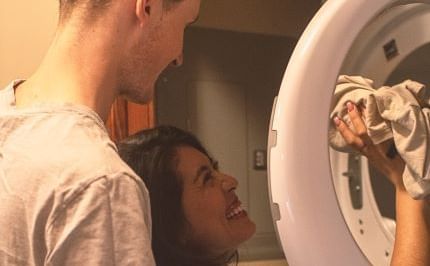 Portrait of a couple putting clothes into the washing machine at Blackstone Mountain Lodge