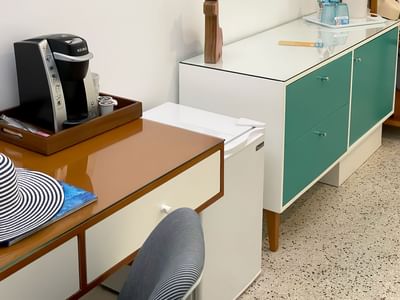 A photo of the coffee maker and fridge found in the electra deluxe room