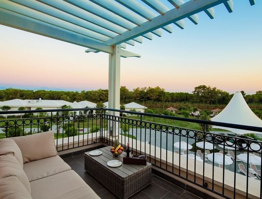Family Pool Suite Balcony with lush greenery view at Titanic Deluxe Golf Belek