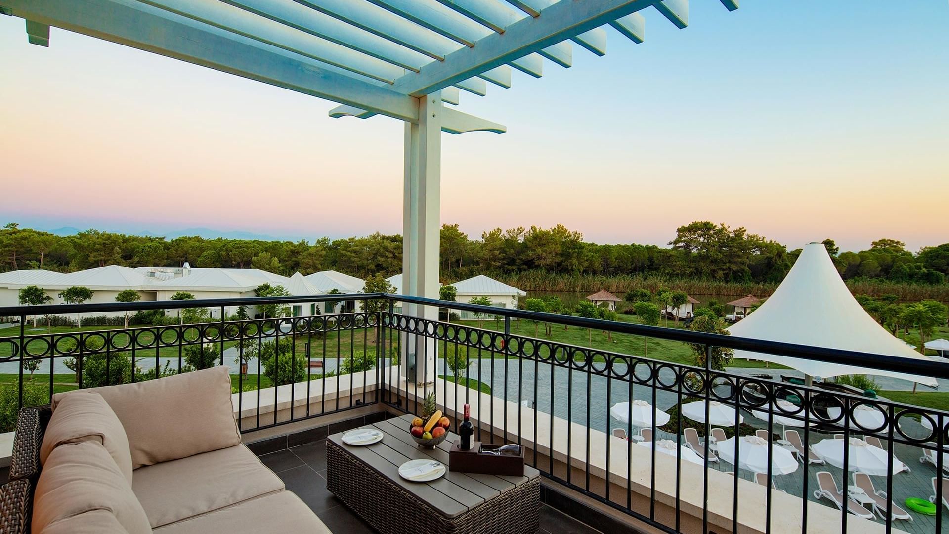 Балкон Family Pool Suite в Titanic Deluxe Golf Belek — вид на зелёную природу и умиротворение.