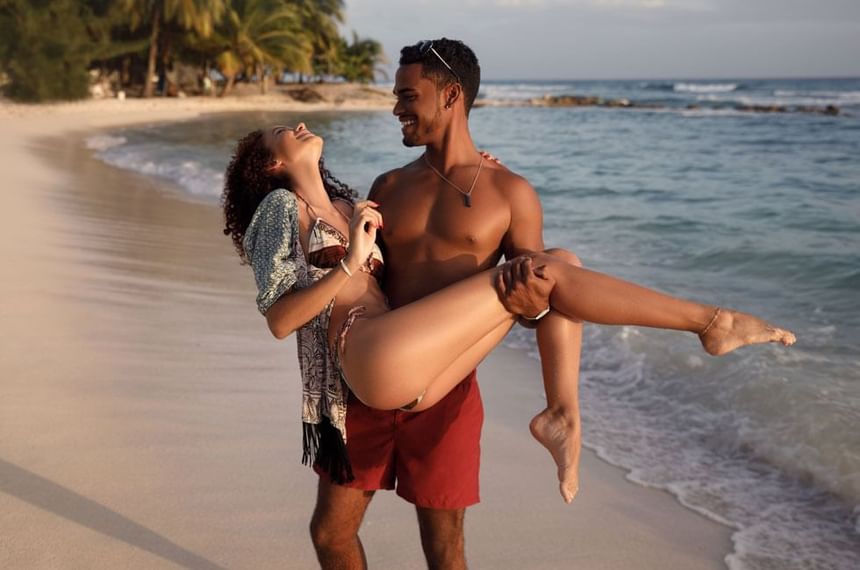 Man holding a woman by the beach at Sugar Bay Barbados
