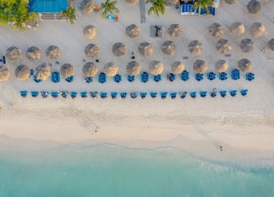 High-angle view of beach with thatched umbrellas and tables arranged near Passions on the Beach
