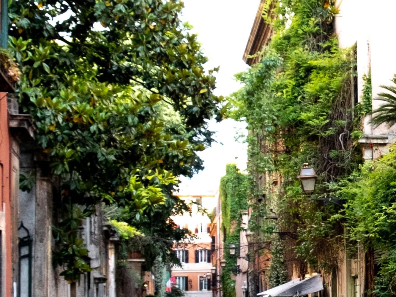 Alley surrounded by trees & old brick buildings near Margutta 19