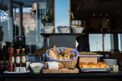 Breakfast buffet with pastries, bread, oils, and croissants beautifully displayed in Azzurro Ristorante at Cala Di Volpe