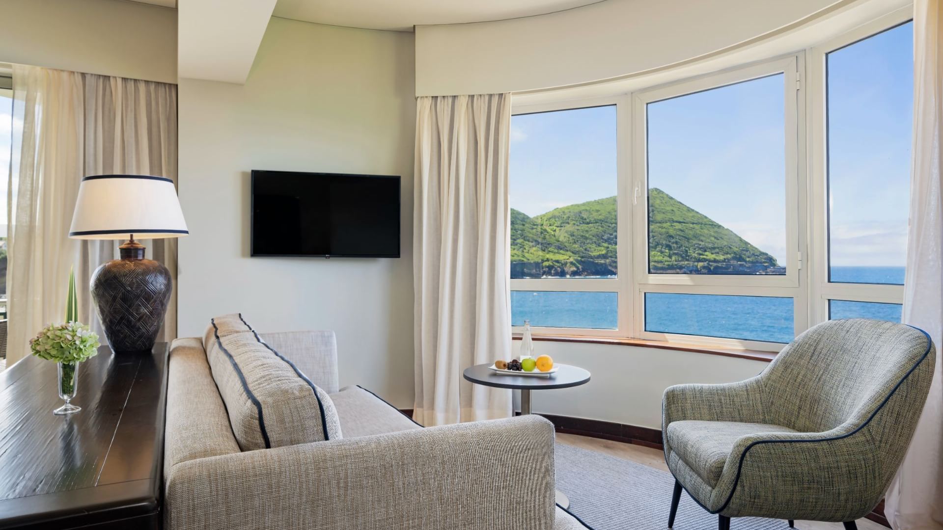 Comfy sofa, TV & ocean view in Junior Suite at Terceira Mar Hotel