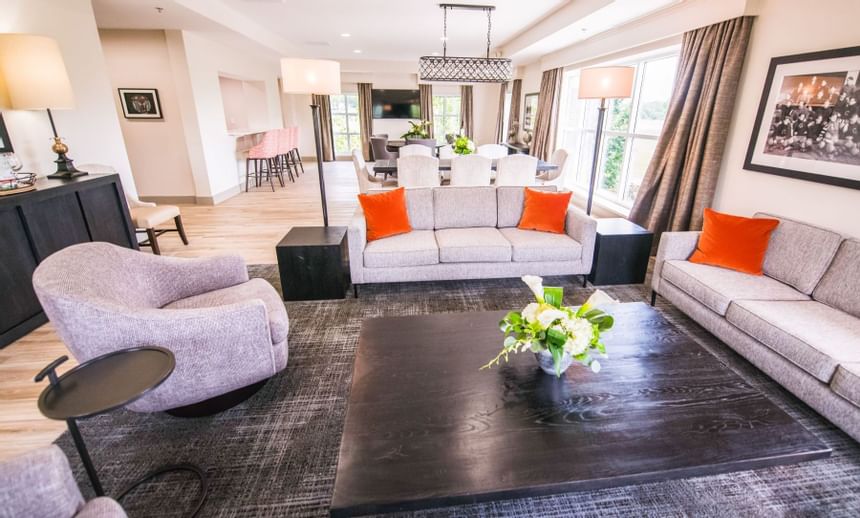 Sofas with orange pillows around a large coffee table in the Hospitality Suite at Clemson University Conference Center & Inn