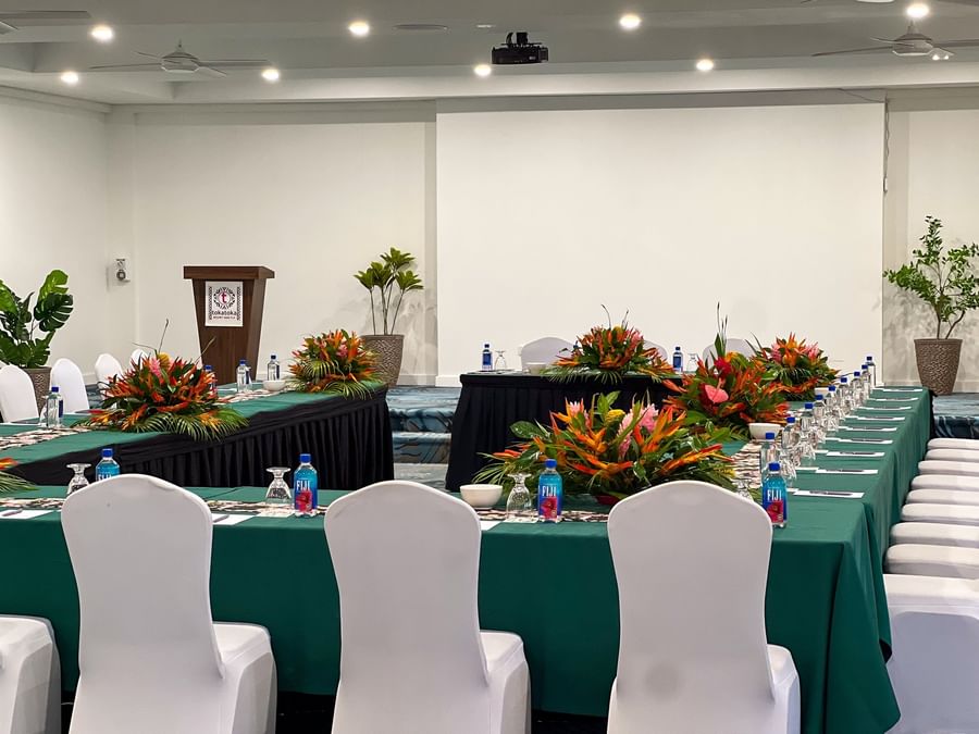 Formal U-shaped conference table featuring tropical floral arrangements and bottled Fiji water at TokaToka Resort Nadi Fiji