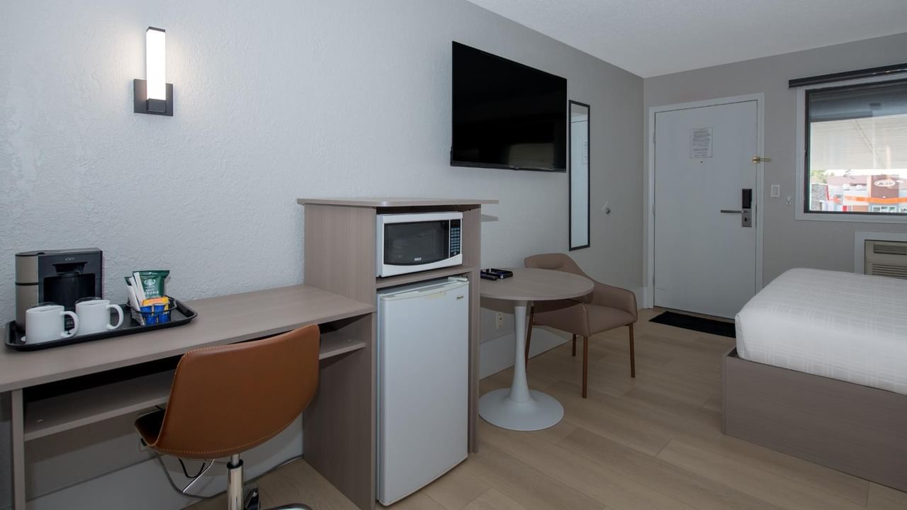 Guest room at Coast Red Deer Hotel with desk, TV, microwave and mini fridge