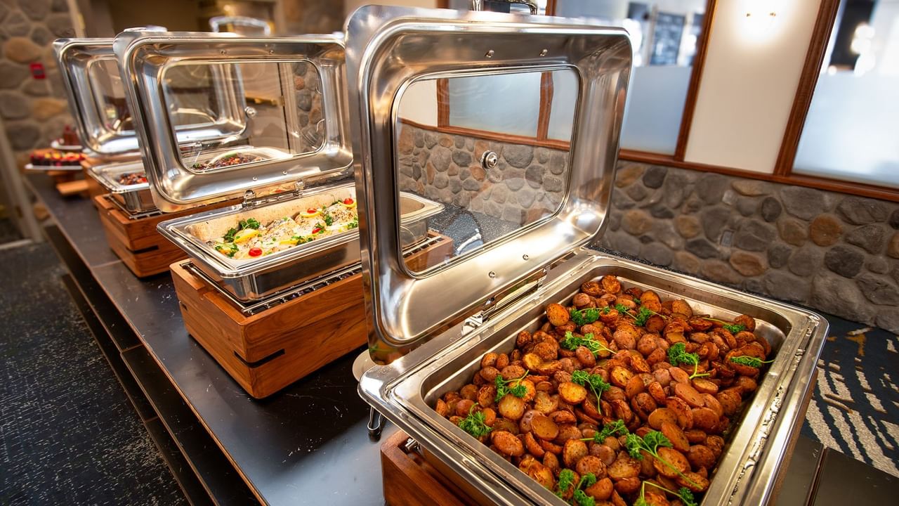 Buffet table with multiple dishes containing roasted vegetables.