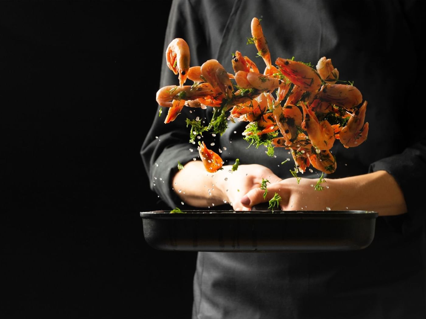 A chef tossing shrimps in a pan at Fiesta America Hotels