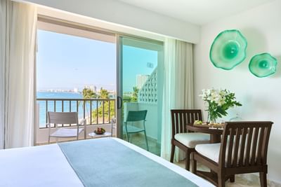 A contemporary resort suite bedroom showing a king-size bed and upscale layout with modern TV setup.