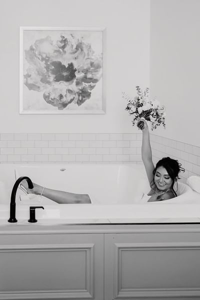 Bride holding up bouquet in a jacuzzi suite at the Hotel at Old Town