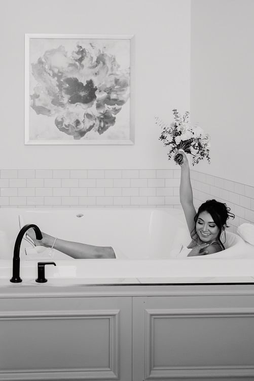 Bride holding up bouquet in a jacuzzi suite at the Hotel at Old Town