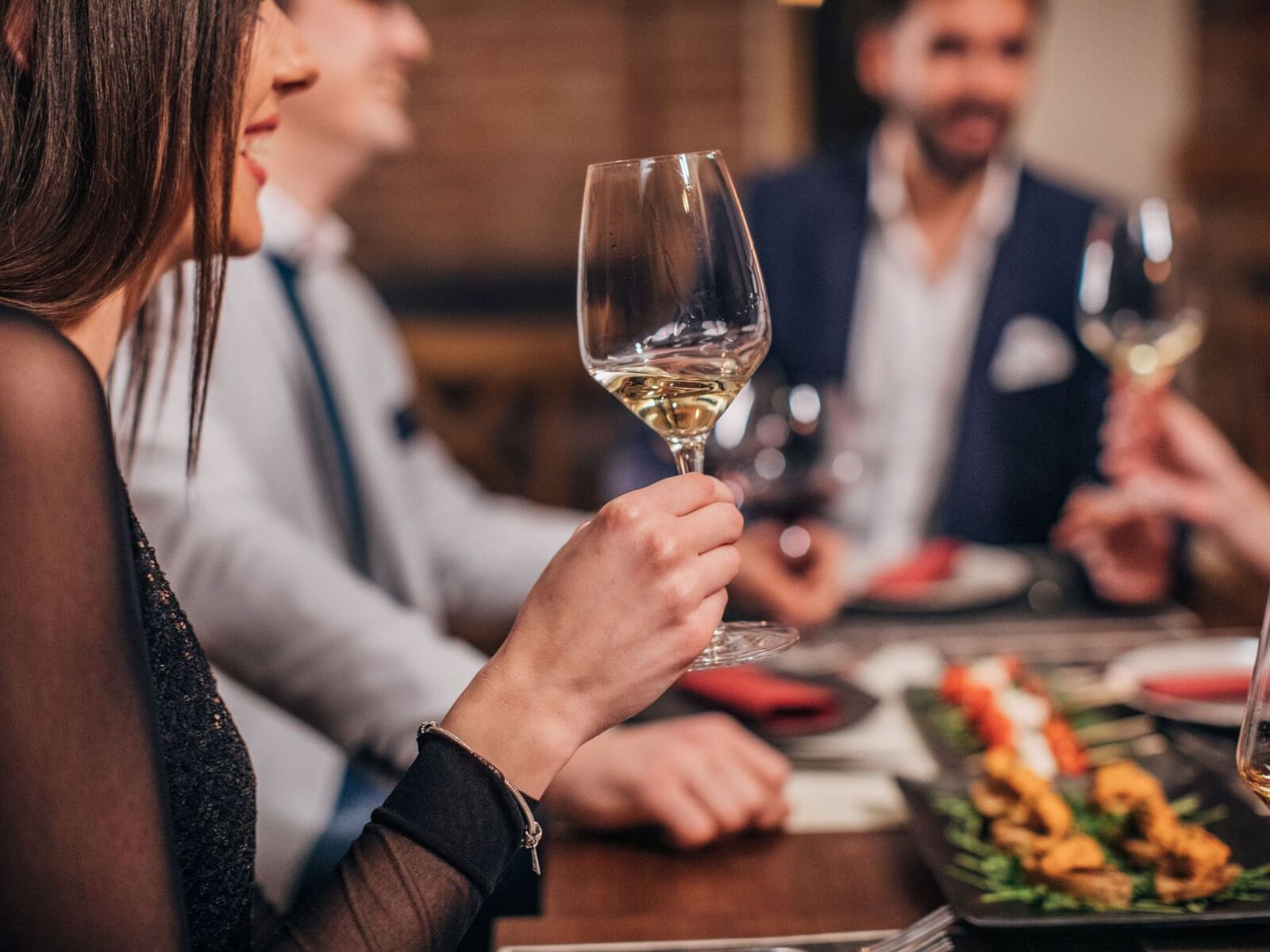 Close-up of friends enjoying champagne on a dinner table at Park Hotel Hong Kong