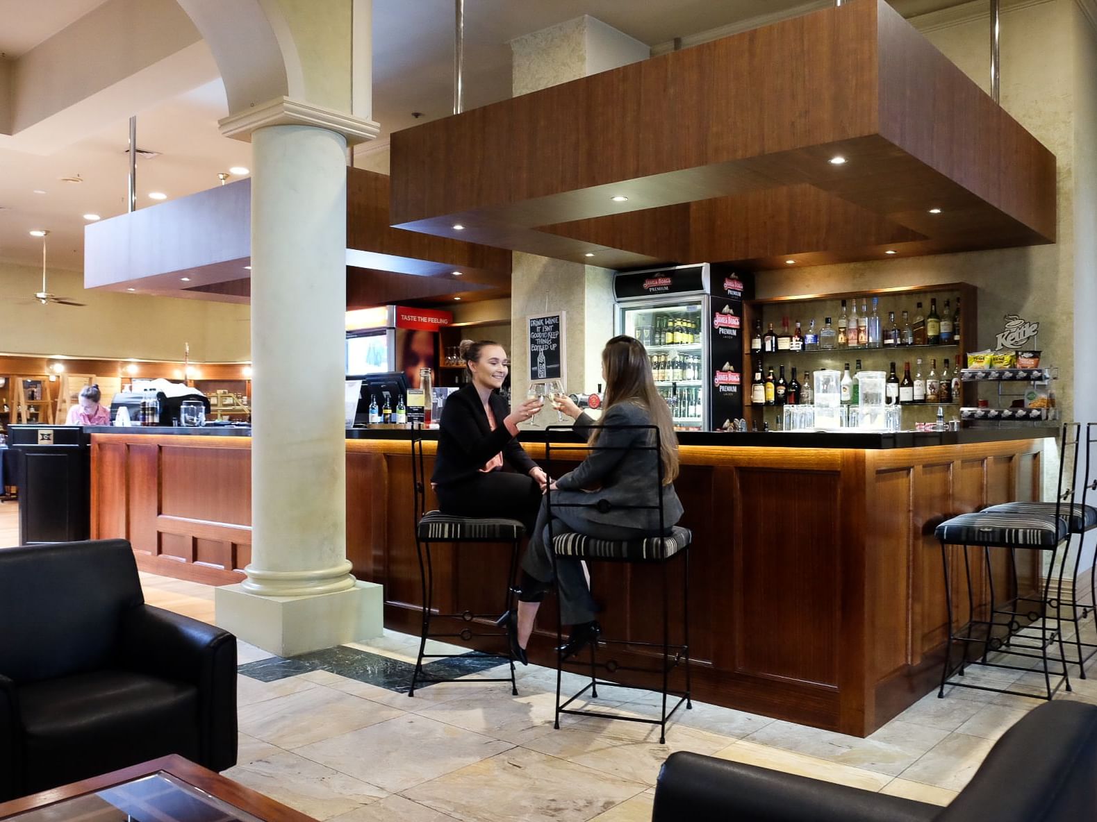 Two women toasting near the bar counter at Hotel Grand Chancellor Launceston