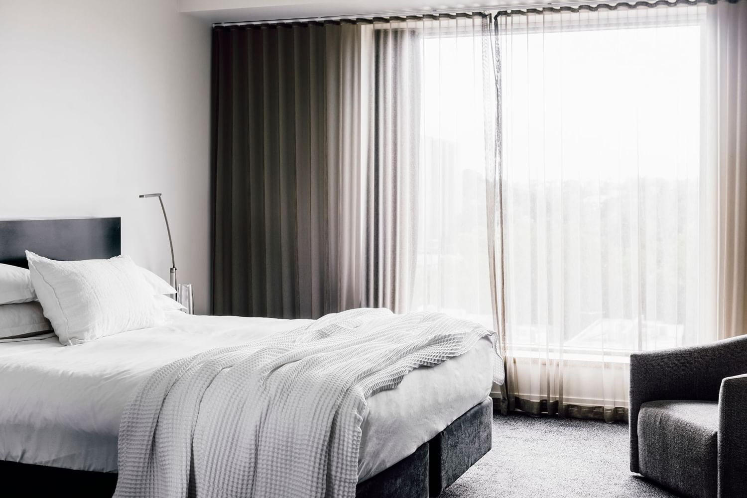 King bed by a window in Superior room at The Como Melbourne