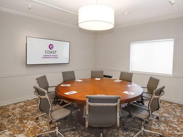 Conference table with eight chairs and a round ceiling light.