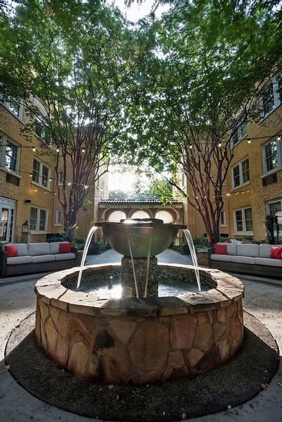 A fountain surrounded by trees at Artmore Hotel