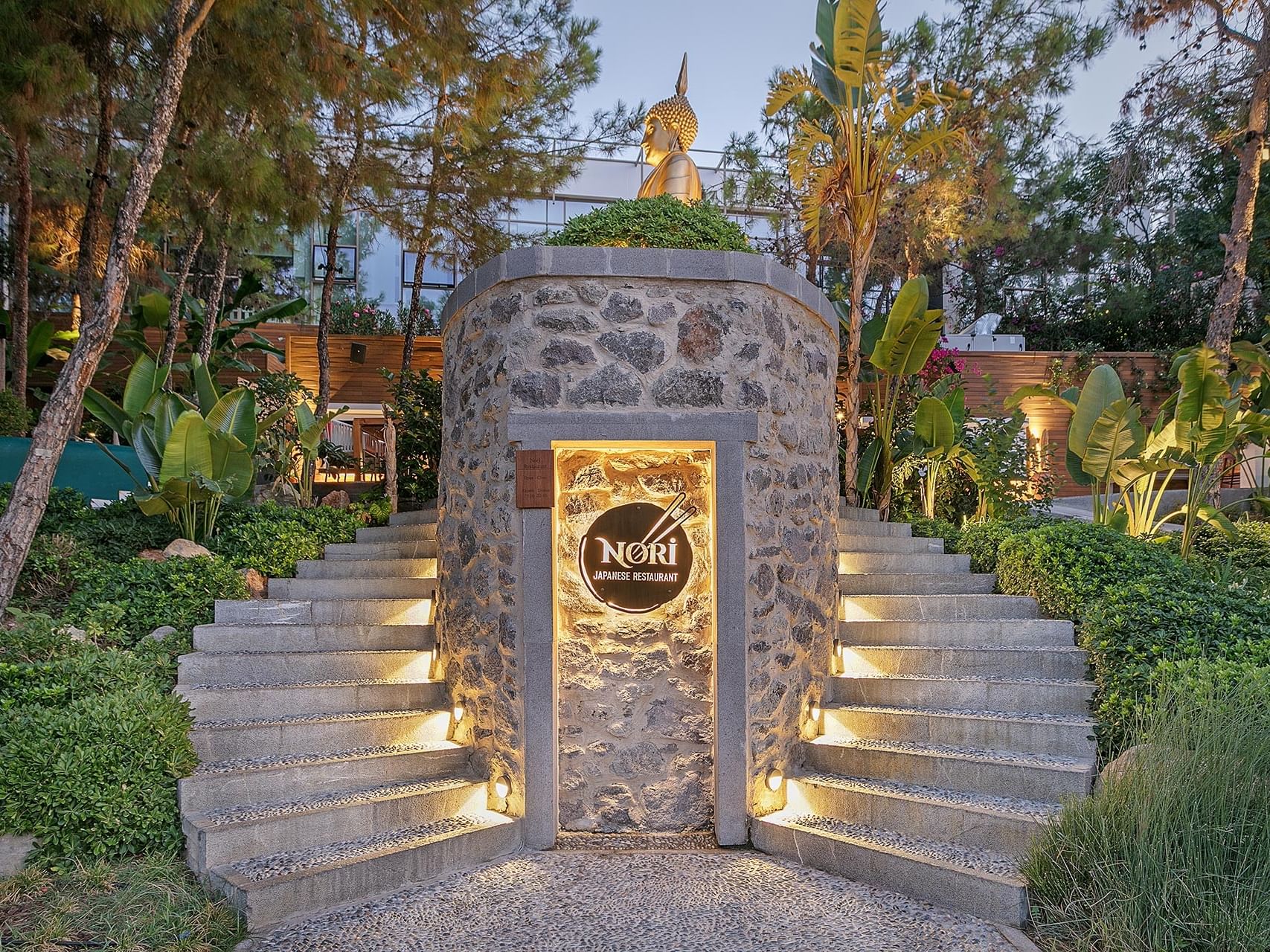 The Japanese restaurant “Nori” at Titanic Luxury Collection Bodrum offers a refined ambiance with its stone entrance and nighttime lighting.