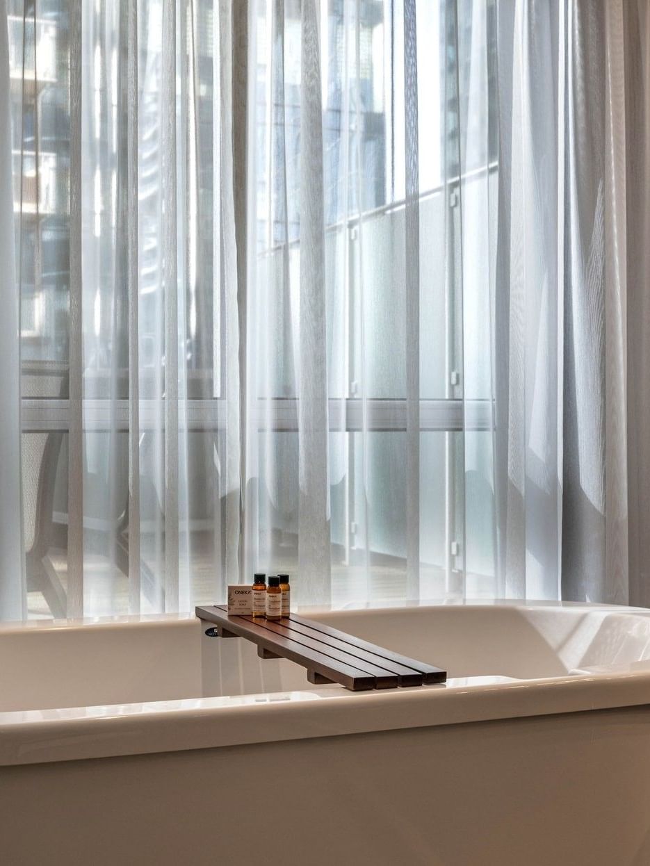 Bathtub with towels and toiletries in the Penthouse De la Montagne at Warwick Le Crystal – Montreal.