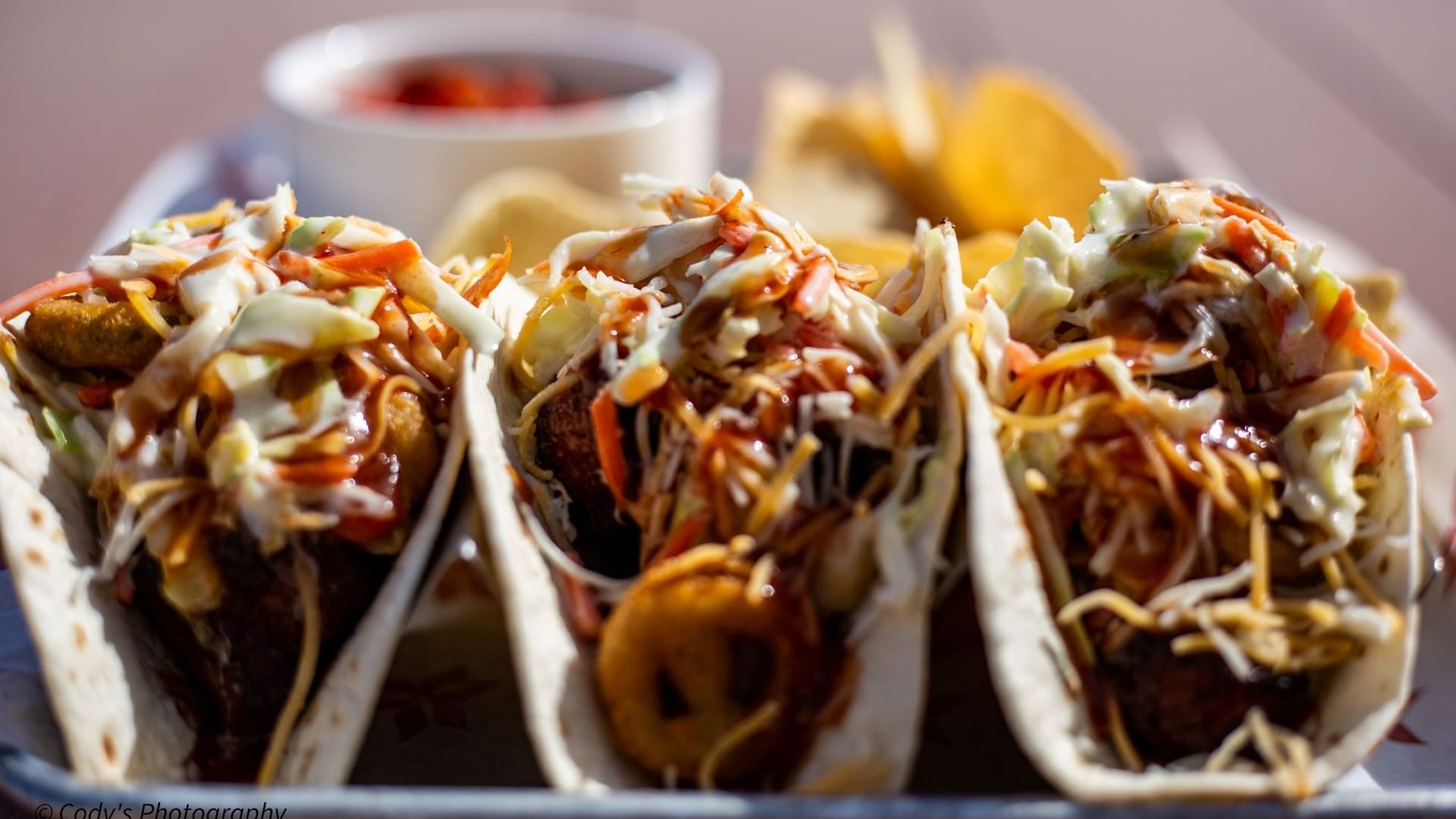 Three tasty tacos filled with fresh slaw and drizzled with sauce, served at Doc's Bar and Grill in Shangri-La Monkey Island