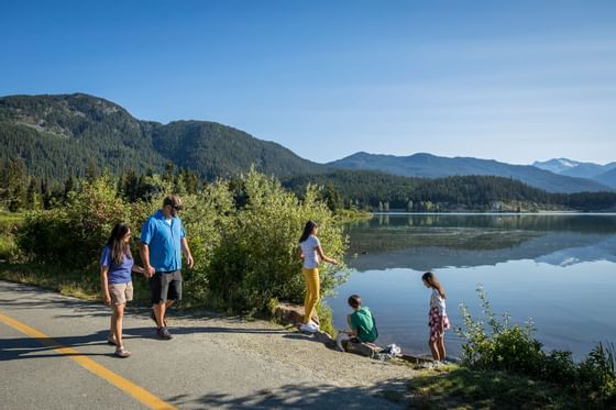 A family exploring serene nature with a lake near Blackcomb Springs Suites