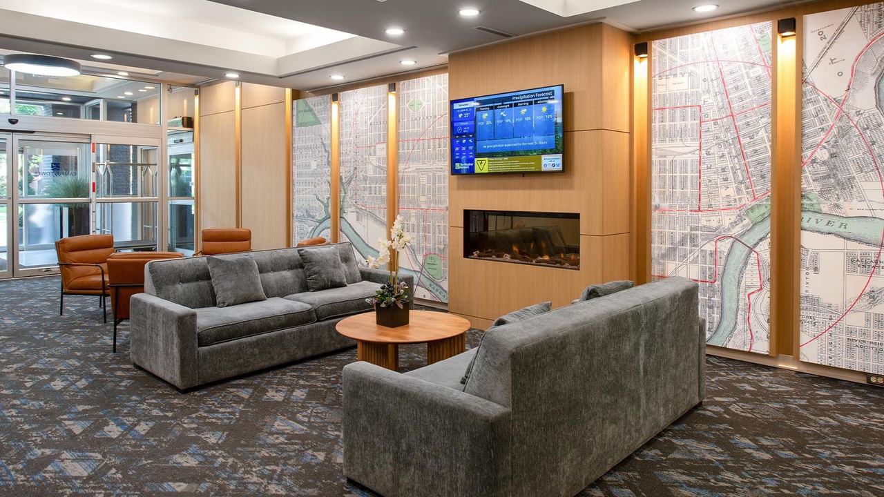 Hotel lobby seating area with sofas, armchairs, a fireplace and TV.