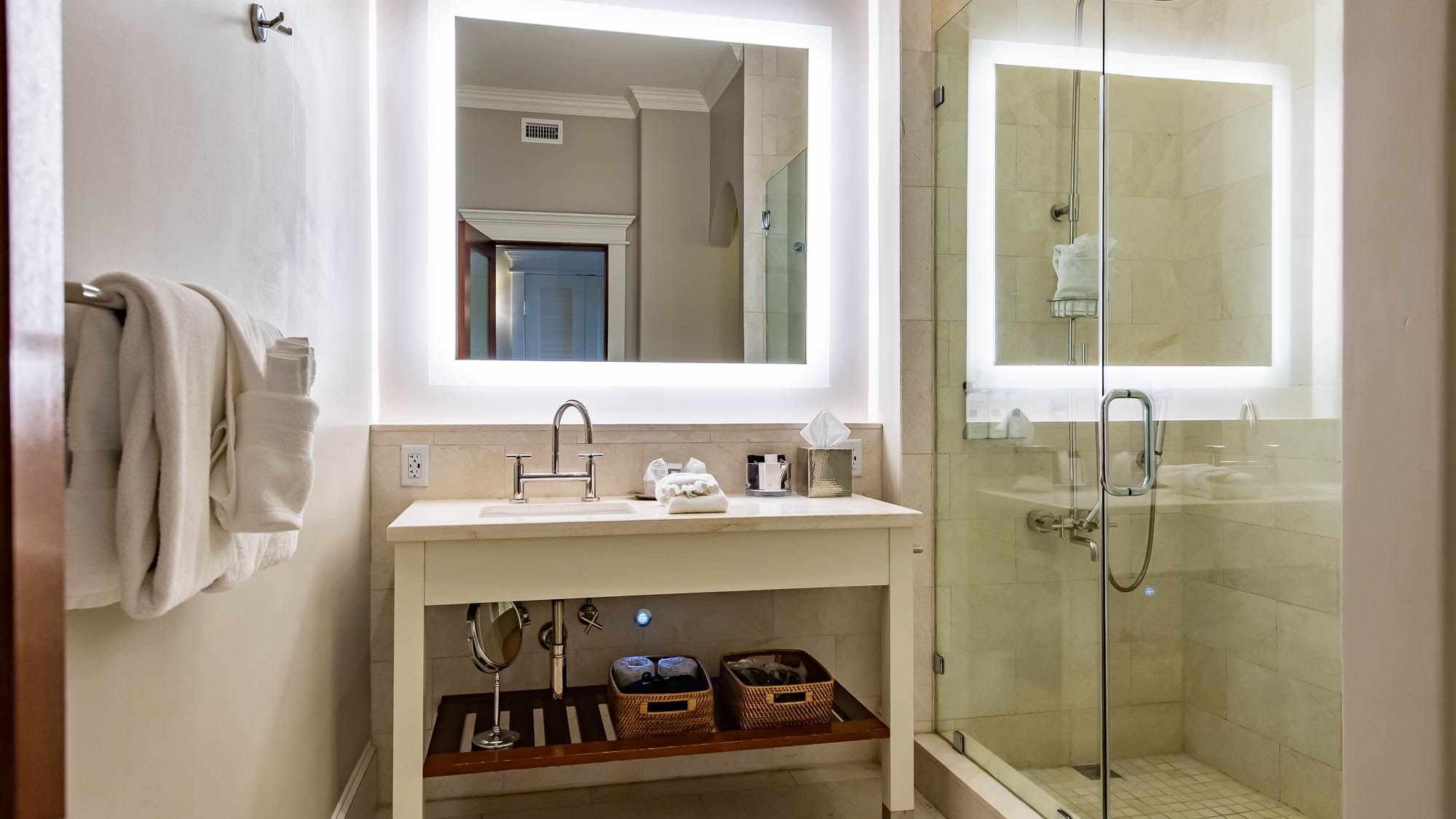 Bathroom with vanity, mirror, and glass shower at The Pearl Hotel in Rosemary Beach.