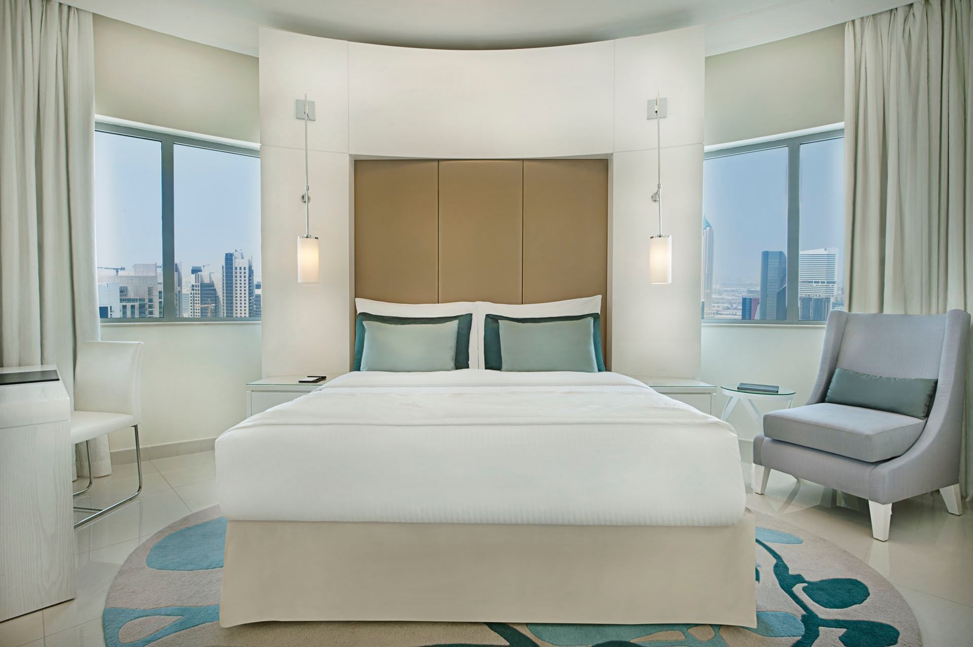 Bed with couch and city view in Deluxe Room at DAMAC Maison Dubai Mall Street