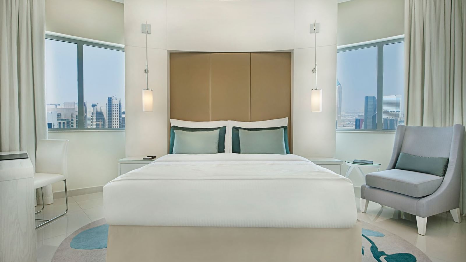 Comfy bed, chairs and city view in One Bedroom Suite at DAMAC Maison Dubai Mall Street