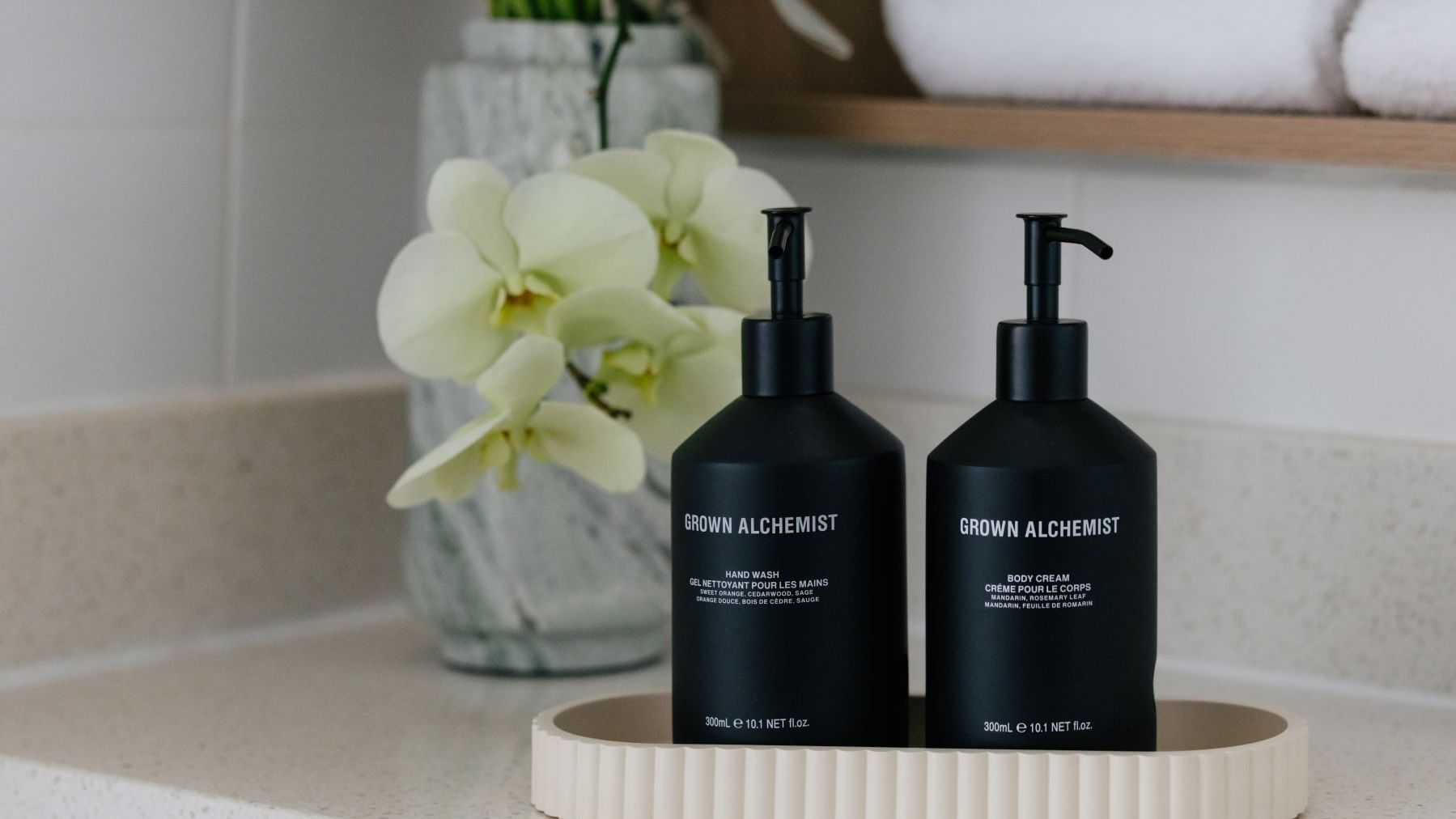 Sunset View Twin at Elysium Manly with Grown Alchemist bottles on a ribbed tray by a glass vase under folded bath towels