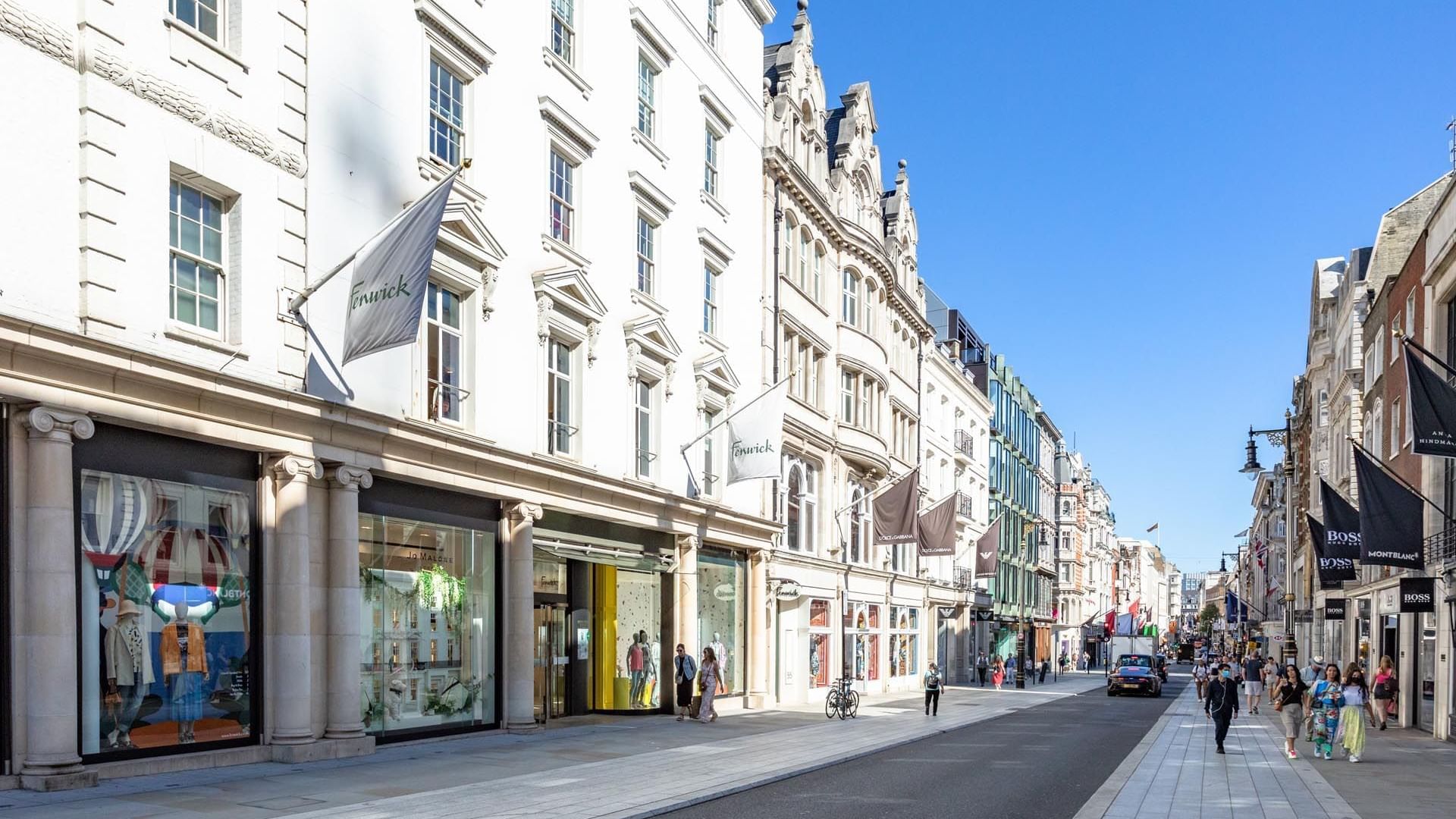 Busy Bond Street with luxury boutiques and pedestrians near The May Fair Hotel