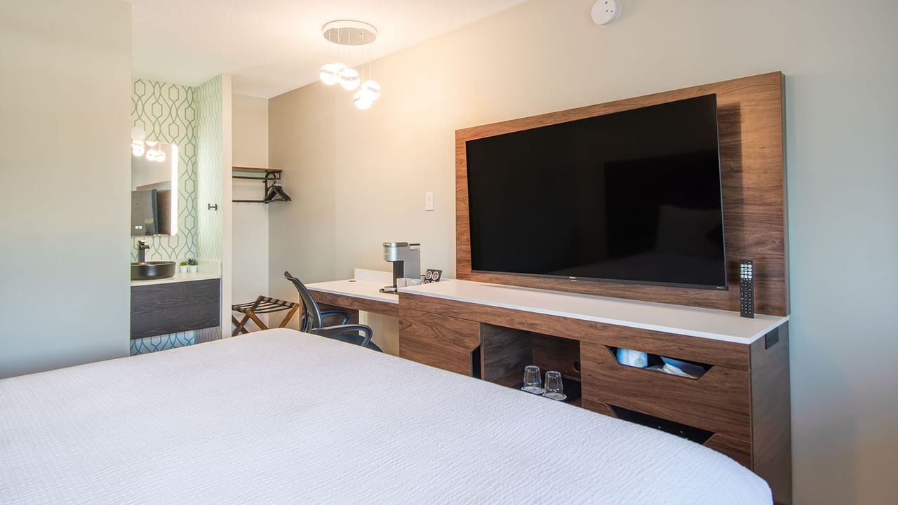 Hotel guest room with king bed, flat screen TV, and work desk