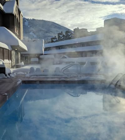 Outdoor heated pool & hot tub in winter at Adara Hotel